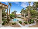 Community pool and lounging area surrounded by tall palm trees and desert landscaping at 2627 S Durango Dr # 201, Las Vegas, NV 89117