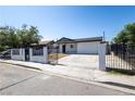 Inviting single-story home with a gated driveway, white exterior, and fresh gravel landscaping for curb appeal at 3601 Broadway Ave, North Las Vegas, NV 89030