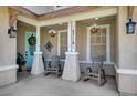 Comfortable front porch features rocking chairs, decorative floral baskets, and a charming blue door at 5716 Breckenridge St, North Las Vegas, NV 89081