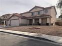 Two-story home featuring a three car garage, tile roof, and a low maintenance front yard at 6449 Elizabethtown Ave, Las Vegas, NV 89110