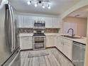 Bright kitchen featuring stainless steel appliances, white cabinets, and a modern backsplash at 6621 Churnet Valley Ave, Las Vegas, NV 89139
