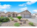 Attractive home showcasing a manicured desert landscape, complemented by a wide driveway and two-car garage at 6781 Alpine Brooks Ave, Las Vegas, NV 89130