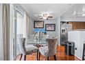 Bright dining area with a glass table, stylish chairs, and sliding glass doors to the outside patio at 701 Harvest Run Dr # 104, Las Vegas, NV 89145
