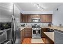 Modern kitchen with stainless steel appliances, wooden cabinets, and durable countertops at 701 Harvest Run Dr # 104, Las Vegas, NV 89145