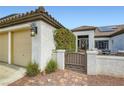 View of a home's entry gate and covered front patio sitting area with a tile roof at 7404 Wittig Ave, Las Vegas, NV 89131
