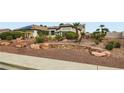 The attractive front yard is xeriscaped with desert vegetation, rocks, and stacked stone accents at 7404 Wittig Ave, Las Vegas, NV 89131