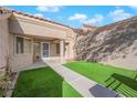 This home boasts a charming courtyard with synthetic grass, providing a cozy outdoor space at 8620 Prairie Hill Dr, Las Vegas, NV 89134