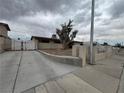 Well-maintained front exterior with a long driveway, small tree, and tan stucco exterior at 1338 Smoke Tree Ave, Las Vegas, NV 89108