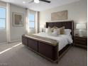 Bright main bedroom with a large bed, two windows, and neutral colors at 1560 Pacific Baza St, Las Vegas, NV 89138