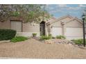 Charming home featuring rock landscaping, mature trees, and a secure gated entrance at 1598 Cowboy Chaps Pl, Henderson, NV 89002