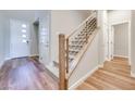 Bright entryway with wood floors, staircase with metal railing, and white doors at 2523 Campaldo St, Henderson, NV 89044