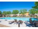 Community pool with lounge chairs and tables, surrounded by trees and well-kept landscaping at 8368 Creek Canyon Ave, Las Vegas, NV 89113