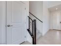 Bright foyer with tile flooring, wooden railing staircase and a white door with brushed metal handle at 860 Echelon St, Las Vegas, NV 89138