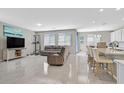 Bright, open-concept living space with tile flooring, seamlessly connecting the living room and kitchen at 949 Bayberry Ridge St, Henderson, NV 89052