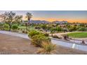 Picturesque golf course view with desert landscaping and mountain views at dusk at 10536 Abisso Dr, Las Vegas, NV 89135