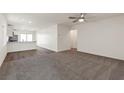 Spacious living area with plush carpeting and an open layout flowing into the kitchen at 1708 Desert Path Ave, North Las Vegas, NV 89032