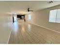 Spacious living room featuring tile flooring and a ceiling fan, perfect for relaxing or entertaining at 4117 Midnight Crest Ave, North Las Vegas, NV 89031