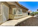 Home exterior featuring desert landscaping, a secure front door, and white trimmed windows at 6057 Leaping Foal St, North Las Vegas, NV 89081