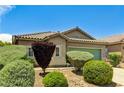 Single-story home featuring lush landscaping, a well-maintained lawn, and desert rock accents at 6057 Leaping Foal St, North Las Vegas, NV 89081