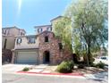 Attractive two-story home with a stone facade, and a tree shading the front, creating curb appeal at 10450 Badger Ravine St, Las Vegas, NV 89178
