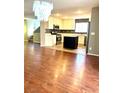 Open-concept kitchen with stainless steel appliances, center island, and hardwood floors at 10450 Badger Ravine St, Las Vegas, NV 89178