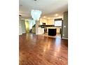 Open-concept kitchen with stainless steel appliances, center island, and hardwood floors at 10450 Badger Ravine St, Las Vegas, NV 89178