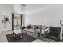 Bright living room featuring a large sofa, a black rug, and sliding glass doors to the patio at 3008 Saint George St # F, North Las Vegas, NV 89030