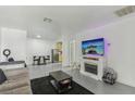 Bright living room with a fireplace, a large sofa, and a view into the adjacent kitchen at 3008 Saint George St # F, North Las Vegas, NV 89030