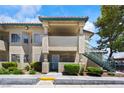 Condo exterior featuring covered entryway, stone facade, and desert landscaping at 338 Jett St # 101, Las Vegas, NV 89145