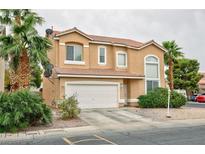 Charming two-story home featuring a terracotta-tiled roof, two-car garage, and lush landscaping with mature palm trees at 6007 Turtle River Ave, Las Vegas, NV 89156