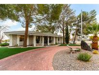 Single-story home with stone exterior, landscaped yard, and brick driveway at 2000 S Monte Cristo Way, Las Vegas, NV 89117