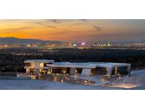 Stunning contemporary home featuring desert landscaping and panoramic views of the Las Vegas skyline at sunset at 4 Horseshoe Rock Ct, Henderson, NV 89012