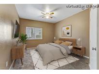 This bedroom features neutral walls, a ceiling fan, soft carpet and a window with views to the outdoors at 5655 E Sahara Ave # 1052, Las Vegas, NV 89142