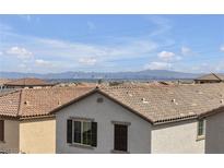 A picturesque view overlooking the cityscape and mountains from the rooftop of a home with a terracotta-tiled roof at 10664 Sariah Skye Ave, Las Vegas, NV 89166