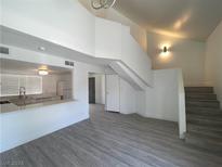 Bright open-concept living room with a modern kitchen view, sleek flooring, and stairs at 4281 White Sands Ave, Las Vegas, NV 89121