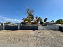 View of a residence with a gated driveway and mature landscaping under a clear blue sky at 3895 Mountain Trl, Las Vegas, NV 89108