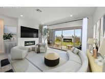 Bright living room features a modern fireplace, TV and an outside patio area with sliding glass doors at 12295 Skyracer Dr, Las Vegas, NV 89138