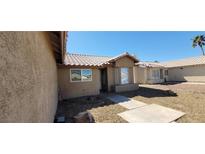 Beige single story home with well manicured rock landscaping, concrete walkway, and tile roof at 3505 Benson Ln, North Las Vegas, NV 89032