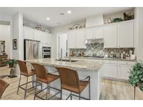 Spacious kitchen featuring granite countertops, stainless steel appliances, and white cabinetry at 10057 Regency Canyon Way, Las Vegas, NV 89148