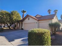 House exterior featuring a two-car garage and well-manicured landscaping at 841 Lusterview Ct, Las Vegas, NV 89123