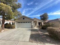 Single-story house with attached garage, stone accents, and landscaped yard at 9804 Panorama Cliff Dr, Las Vegas, NV 89134