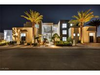 Striking modern home featuring palm trees, stone accents, and an inviting entrance at nighttime at 9760 Solar Ave, Las Vegas, NV 89149