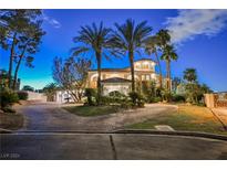 Elegant home featuring lush landscaping, circular driveway, and inviting entrance with palm trees at 2349 Villandry Ct, Henderson, NV 89074