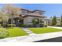 Stunning two-story home features a lush green lawn, manicured landscaping, and a modern architectural design at 17 Winding Rd, Henderson, NV 89052