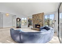 Spacious living room featuring a stone fireplace and a large curved sofa at 2761 Cape Hope Way, Las Vegas, NV 89121