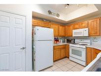 Bright kitchen with oak cabinets, white appliances, and ample counter space at 5855 Valley Dr # 1028, North Las Vegas, NV 89031