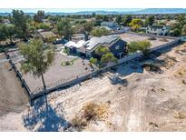Expansive property with dark siding, solar panels, a secure fence, and pristine desert landscaping at 7135 Polaris Ave, Las Vegas, NV 89118