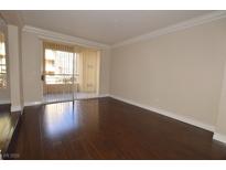 Bright living room with dark hardwood floors and access to a balcony at 270 E Flamingo Rd # 107, Las Vegas, NV 89169