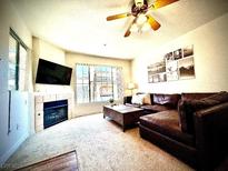 Spacious living room with a cozy fireplace and large TV at 7135 S Durango Dr # 204, Las Vegas, NV 89113