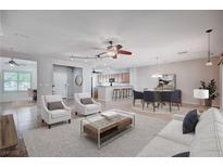 Bright and airy living room featuring a ceiling fan, neutral decor, and an open floor plan at 7457 Widewing Dr, North Las Vegas, NV 89084